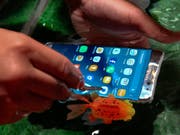 Samsung-Handys werden in der Werbung auf dem Boden eines Schwimmbeckens oder im Meer benutzt. Das hat dem Telekomkonzern nun eine Klage der australischen Wettbewerbsbehörde eingebrockt. (Bild: KEYSTONE/EPA/RITCHIE B. TONGO)