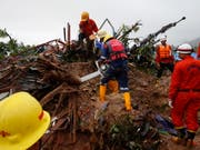 Nach einem Erdrutsch in Myanmar suchten Rettungskräfte am Samstag nach Vermissten. Offiziellen Angaben zufolge könnten noch bis zu 100 Menschen verschollen sein. (Bild: KEYSTONE/EPA/LYNN BO BO)