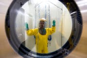 Nach der Arbeit im biologischen Hochsicherheitslabor in Spiez müssen die Forscher eine Prozedur zur Dekontamination durchlaufen. Hier steht ein Virologe unter einer Chemiedusche. (Bild Peter Schneider/Keystone (19. November 2014))
