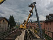 Der schiefstehende Drehbohrer drohte von den SBB-Gleisen auf das Mehrfamilienhaus (rechts) zu fallen. (Bild: Kantonspolizei Zug)