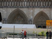 Arbeiter am Dienstag beim Aufbauen von Zäunen, die den Zutritt zu einem ersten Bereich vor der Kathedrale versperren. (Bild: KEYSTONE/AP/FRANCOIS MORI)