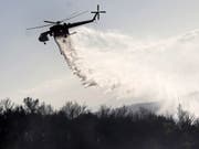 Ein Löschhelikopter hilft bei der Bekämpfung eines Brandes auf dem Berg Ymmitos ausserhalb Athens. (Bild: Keystone/EPA/KOSTAS TSIRONIS)