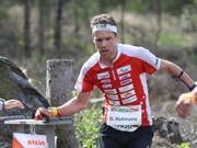 Daniel Hubmann stempelt mit dem Chip am Handgelenk den Posten ab. (Bild: KEYSTONE/SWISS ORIENTEERING/REMY STEINEGGER)
