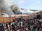 Aus Protest gegen eine kanadische Silbermine in Peru setzten Demonstranten im Mai 2011 mehrere Gebäude in der Provinz Puno in Brand. (Bild: KEYSTONE/EPA/STR)