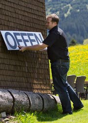 Pascal Moser bringt ein «Offen»-Schild an. Die Gade Lodge bleibt auch weiterhin offen, Moser zieht aber weiter. (Bild: Jonny Schai, 4. Juni 2013)