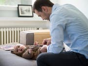 Väter sollen nach der Geburt eines Kindes zwei Wochen bezahlten Vaterschaftsurlaub nehmen können. Die Nationalratskommission unterstützt eine entsprechende Gesetzesänderung. (Bild: KEYSTONE/GAETAN BALLY)