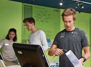 Langläufer Beda Klee (rechts) und Musiker Nickless erhalten an der Kasse Informationen zu den Produkten, welche sie ausgewählt haben. (Bild: Michael Hehli)