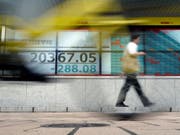 Nicht nur in der Schweiz sind die Börsenkurse gesunken, auch in Asien. Im Bild: Kursanzeige bei einer Bank in Tokio. (Bild: KEYSTONE/AP/EUGENE HOSHIKO)