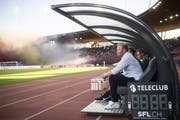 FCZ-Trainer Ludovic Magnin verfolgt das Spiel gegen den FCSG. Im Hintergrund werden Pyros gezündet. (Bild: Keystone)
