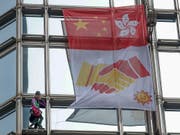 Der Extremkletterer Alain Robert rollte am Freitag in Hongkong an einem Wolkenkratzer ein «Friedensbanner» aus. (Bild: KEYSTONE/AP/VINCENT THIAN)