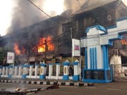 Demonstranten in West-Papua haben am Montag das lokale Parlamentsgebäude in Brand gesetzt, weil das Gerücht umlief, dass ein Demonstrant bei einer Kundgebung am Freitag ums Leben gekommen sei. (Bild: KEYSTONE/EPA/STRINGER)