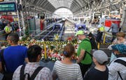 Passanten stehen im Frankfurter Hauptbahnhof vor den Blumen und Stofftieren, die an den getöteten Achtjährigen erinnern. (Bild: Keystone/dpa/Arne Dedert)