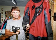 Tauchlehrer Richard Schröter mit einem Trockenanzug, der im kühlen Bodenseewasser mit Vorteil verwendet wird. Die erste Stufe (links) wird an der Pressluftflasche befestigt und muss kaltwassertauglich sein, was heute in der Regel die Norm ist. (Bild: Rudolf Hirtl)