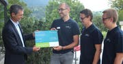Daniel Portmann von «Zentralschweiz innovativ» überreicht den symbolischen Scheck an die Jungunternehmer Cyrill Burch, Meinhard und Manfred Meintjes (v.l.) Bild: Marion Wannemacher (Sarnen, 21. August 2019)