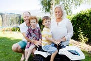 Oscar Adby (4) sitzt auf seinem Spielzeug-Traktor, umgeben von seinen Liebsten: Vater Richard, Zwillingsschwester Elin und Mutter Camilla Adby in ihrem Garten in Wiedlisbach (BE). (Bild: André Albrecht)