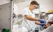 Eine der Pflegefachfrauen legt eine Infusion. (Bild: Reto Martin)