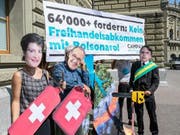 Gegen das Mercosur-Abkommen: Als Simonetta Sommaruga, Guy Parmelin und Jair Bolsonaro Maskierte bei der Petionsübergabe. (Bild: Ben Zumbühl/Campax)
