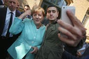 Das Bild des Selfies ging um die Welt: Anas Modamani mit Kanzlerin Merkel in einem Flüchtlingsheim in Berlin-Spandau am 10. September 2015. (Bild Sean Gallup/Getty)