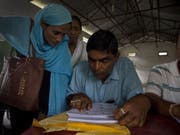 Dorfbewohner von Barburi im indischen Bundesstaat Assam kontrollieren, ob ihre Namen ins Nationale Bürgerregister aufgenommen worden sind. (Bild: Keystone/AP/ANUPAM NATH)