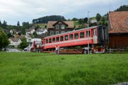 Passanten machen ein letztes Bild vom Bahnwagen, der die Werkstatt in Gais auf der Strasse verlässt. Bild: Karin Erni