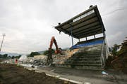 Abbrucharbeiten beim alten Allmend-Stadion. Bagger reissen die letzten Reste der Tribüne ab. Links ein Trümmerhaufen aus den Resten des Stadions. (Bild: Manuela Jans, 26. August 2009)