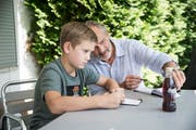 Der Grafiker und Illustrator Ludek Martschini hilft dem zehnjährigen Carl Hess, wie man eine Cola-Flasche fotografiert. Bild: Manuela Jans-Koch (Luzern, 8. August 2019)