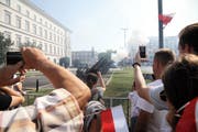 Besucherinnen und Besucher beobachten und filmen die Zeremonie auf dem Pilsudski-Platz. (Bild: EPA)