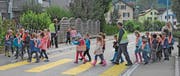 Kindergärtler überqueren unter Aufsicht auf einem Fussgängerstreifen die Thurfeldstrasse in Schönenberg. (Bild: Georg Stelzner)