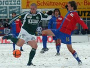 Tanz auf dem schneebedeckten Espenmoos-Rasen: St.Gallens Eric Hassli (links) zieht gegen Basels Patrick Müller ab. (Bild: Keystone)