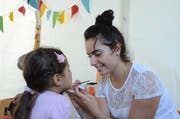 Siria Raffaele, Lernende Fachfrau Betreuung, schminkt eine junge Wiga-Besucherin.