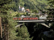 Ein Güterzug mit mehreren Lokomotiven passiert auf der Gotthardstrecke bei Wassen eine Eisenbahnbrücke. Der Güterverkehr durch die Schweizer Alpen hat im ersten Halbjahr 2019 abgenommen - auf der Strasse ebenso wie auf der Schiene. (Bild: Keystone/MARTIN RUETSCHI)