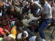 Chaotische Szenen bei der Aufbahrung von Robert Mugabe im Rufaro Stadium in Harare: Ein Polizist versucht Ordnung zu schaffen. (Bild: KEYSTONE/AP/THEMBA HADEBE)