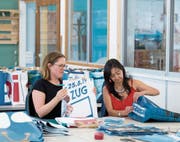 GGZ-Gruppenleiterin Pia Theiler (links) und Silvia Garcia prüfen die aus den Esaf-Werbeplanen genähten Taschen. (Bild: Maria Schmid, Baar, 12. September 2019)