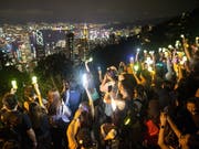 Regierungskritiker in Hongkong bilden am Victoria Peak eine Menschen- und Lichterkette. (Bild: KEYSTONE/EPA/JEROME FAVRE)