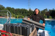 Thomas Kroll bringt die Eisbrecher an: Sie schützen das Schwimmbad im Winter bei Eis und Wetter vor Schäden. (Bild: Jessica Nigg)