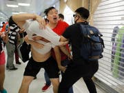 Rangeleien zwischen einem Peking-freundlichen Demonstranten (im roten T-Shirt) und China-kritischen Demonstranten im Einkaufszentrum Amoy Mall. (Bild: KEYSTONE/AP/KIN CHEUNG)