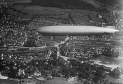 Der Zeppelin LZ127 schwebt vor 1937 über dem Haupt- und Güterbahnhof St.Gallen. Gut zu erkennen ist das Halbrund der Lokremise. Und rechts davon stehen am Nordrand der Kreuzbleiche die Reithalle, das Zeughausmagazin und die Kaserne St.Gallen. (Bild: Stadtarchiv der Ortsbürgergemeinde St.Gallen/Sammlung Foto Gross)