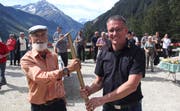Projektleiter Urs Thali (links) überreicht Bürgerratspräsident Beat Tresch einen Spaten, womit die Rinnen an der neuen Strasse gut geeinigt werden können. Bild: Paul Gwerder (14. September 2019)