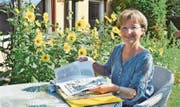Regula Raas blättert in einem Ordner mit alten Programmflyern und Presseartikeln über das Kulturforum Pfyn. (Bild: Evi Biedermann)