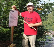 Künstler Niklaus Lenherr montierte gestern am Staldenweg in Bürglen die Tafeln des Lyrik-Weges.Bild: Paul Gwerder