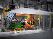Automatisierte Fertigung von Teilen: Der Schweizer Autozulieferer Autoneum beliefert Hersteller weltweit mit Komponenten für den Schall- und Wärmeschutz in Fahrzeugen. (Bild: KEYSTONE/GAETAN BALLY)