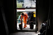 Arbeiter transportieren den Gussasphalt für das Treppenhaus. (Bild: Stefan Kaiser, Menzingen, 9. September 2019)