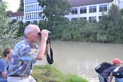 Andreas Meyer beobachtet mit einem Fernglas, wie ein Biber in der Thur schwimmt. (Bild: Adi Lippuner)