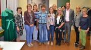 Von links: Yvonne Slongo, Vorsteherin Amt für Berufsbildung, Nicole Leyssing-von Ah, Expertin Swiss Skills Team, Nadine Brand, Vereinsvorstand, Alois Stöckli, Vater, Diplomgewinnerin Denise Stöckli, Annalise Russi, Präsidentin des Vereins Lehratelier für Bekleidungsgestalter, Bea Stöckli, Mutter, Dorothea Michel, Vereinsvorstand, Regierungsrat Beat Jörg, Gerda Walker, Atelierleiterin, und Barbara Infanger, Vereinsvorstand. Links im Bild der an den World Skills von Denise Stöckli in 12,5 Stunden angefertigte Mantel. (Bild: PD)