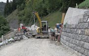 Equipen arbeiten an der Wiesenbergstrasse: Die erste Gruppe ist an der Natursteinverkleidung der Stützmauer und die zweite Gruppe erstellt die Planie für den folgenden Belagseinbau. (Bild: PD)