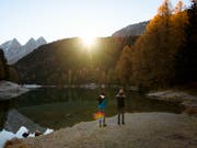 Zwei Jugendliche fotografieren einen Sonnenaufgang: Junge Menschen sollen einen Trend setzen, indem sie klimafreundlich reisen. (Bild: KEYSTONE/GIAN EHRENZELLER)