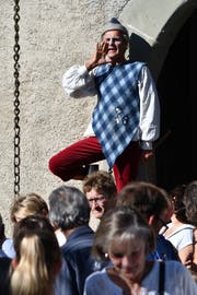 Ein Gaukler steht auf dem Geländer der Zugbrücke und unterhält die Besucher des Erntedankfestes. (Bild: Manuel Nagel)