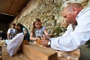 Schreiner Franz Warger (r.) stellt mit den Kindern Arvenkissen her. Die Holzspäne wegzuhobeln ist gar nicht so einfach. (Bild: Manuel Nagel)