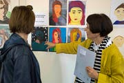 Silvia Peters von der Frauenfelder Bildschule schaut sich mit einer Besucherin die Porträts von Frauenfelder Schülerinnen und Schülern an. (Bild: Andreas Taverner)