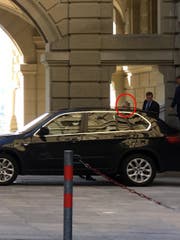 Bundesanwalt Michael Lauber (links, eingekreist, fast ganz verdeckt vom wartenden BMW der Personenschützer), gestern beim Abgang durch eine Hintertür im Bundeshaus. Rechts neben ihm Alexander Medved, sein Rechtskonsulent. Ganz rechts ein Personenschützer.